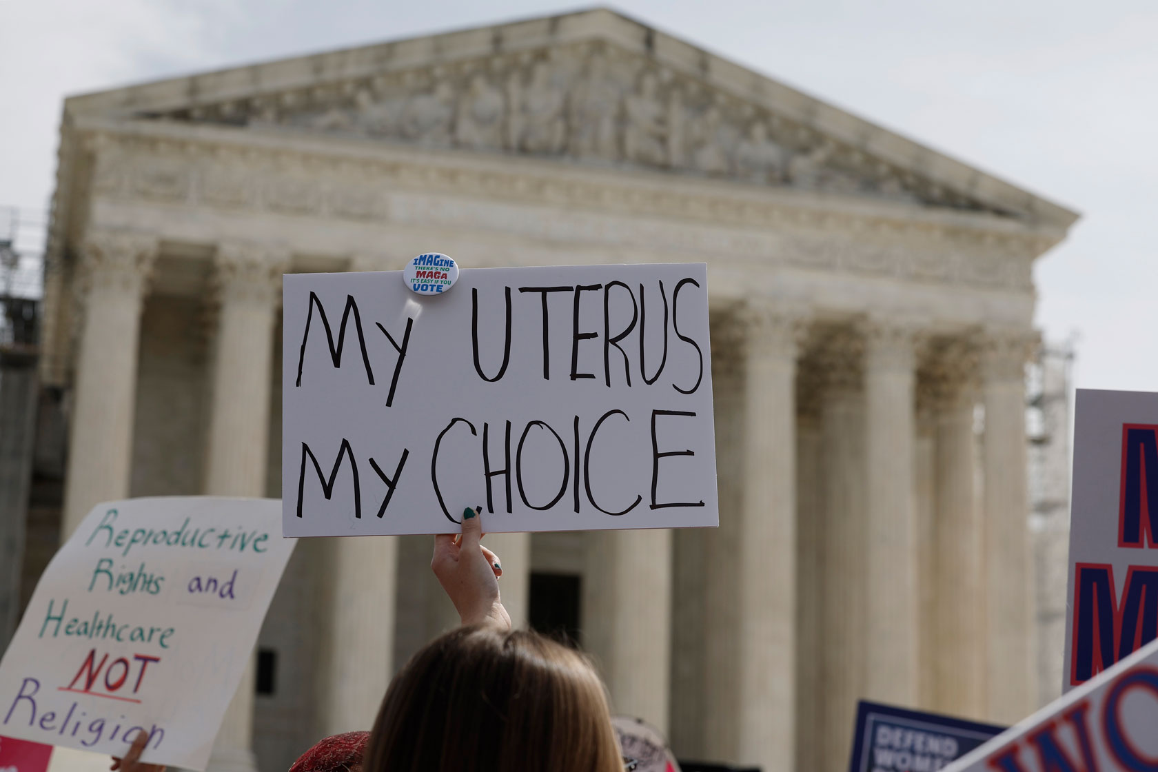 A demonstrator holds a sign in front of the U.S. Supreme Court building.