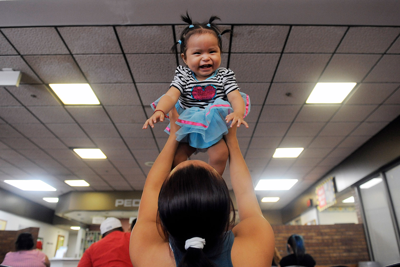 Woman lifting smiling daughter into the air