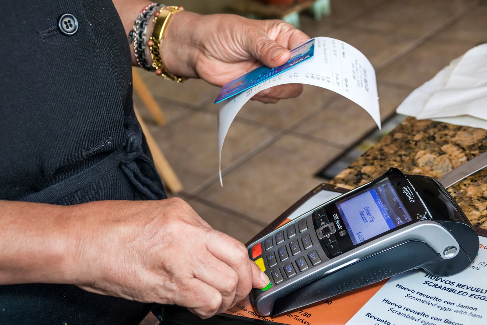 A Miami Beach, Florida, restaurant worker runs a bill.