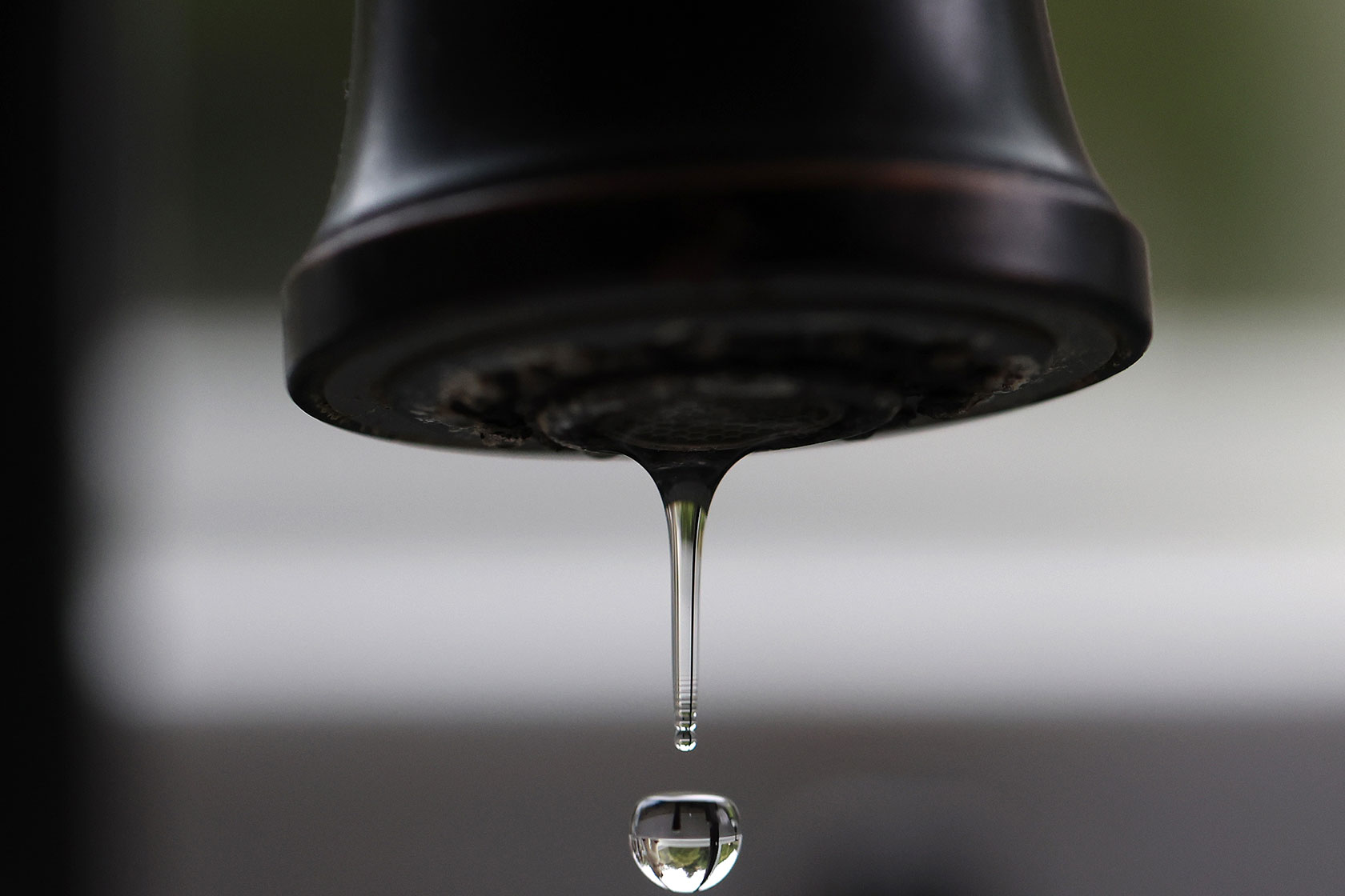 Close-up of drop of water dripping from faucet