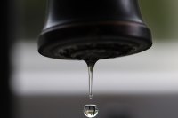 Close-up of drop of water dripping from faucet