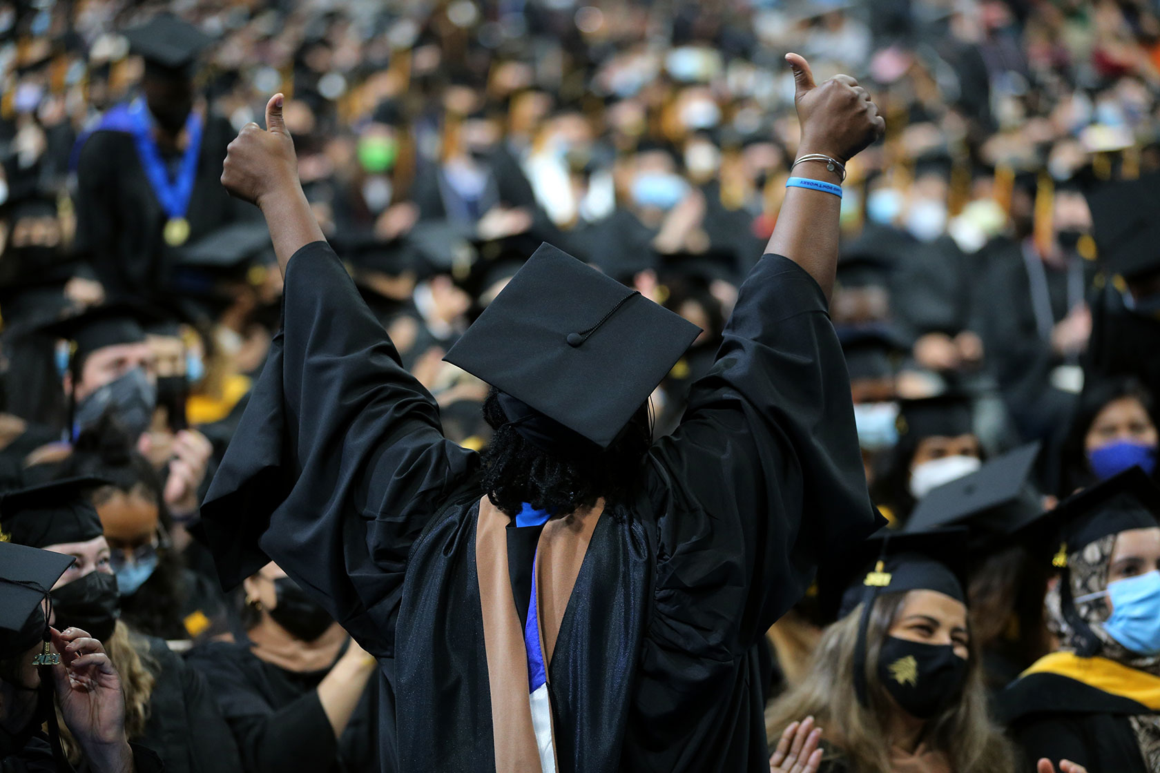 Biden-Harris Administration Unveils Ambitious Student Debt Relief Plans 4 A graduating student celebrates during the university of massachusetts boston commencement ceremony.