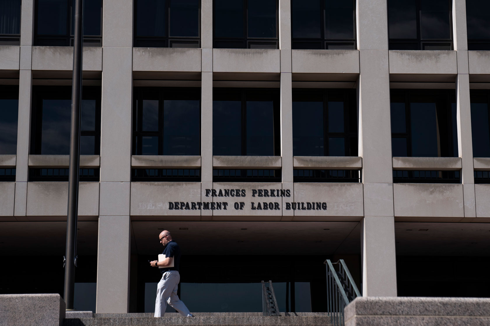 A man walks past the entrance to the U.S. Department of Labor building.