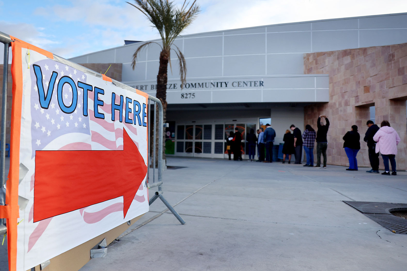Photo shows a sign in the foreground featuring a prominent red arrow and reading 