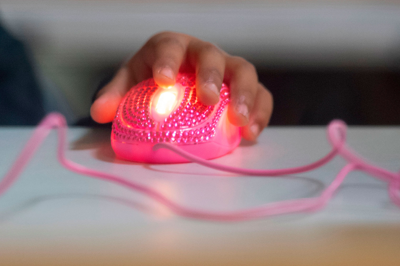 Students hand on pink computer mouse