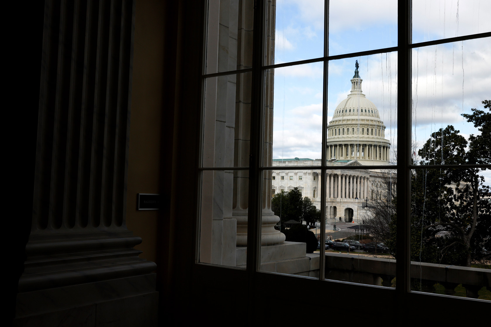 The U.S. Capitol building is seen from the window of a nearby building in Washington, D.C.