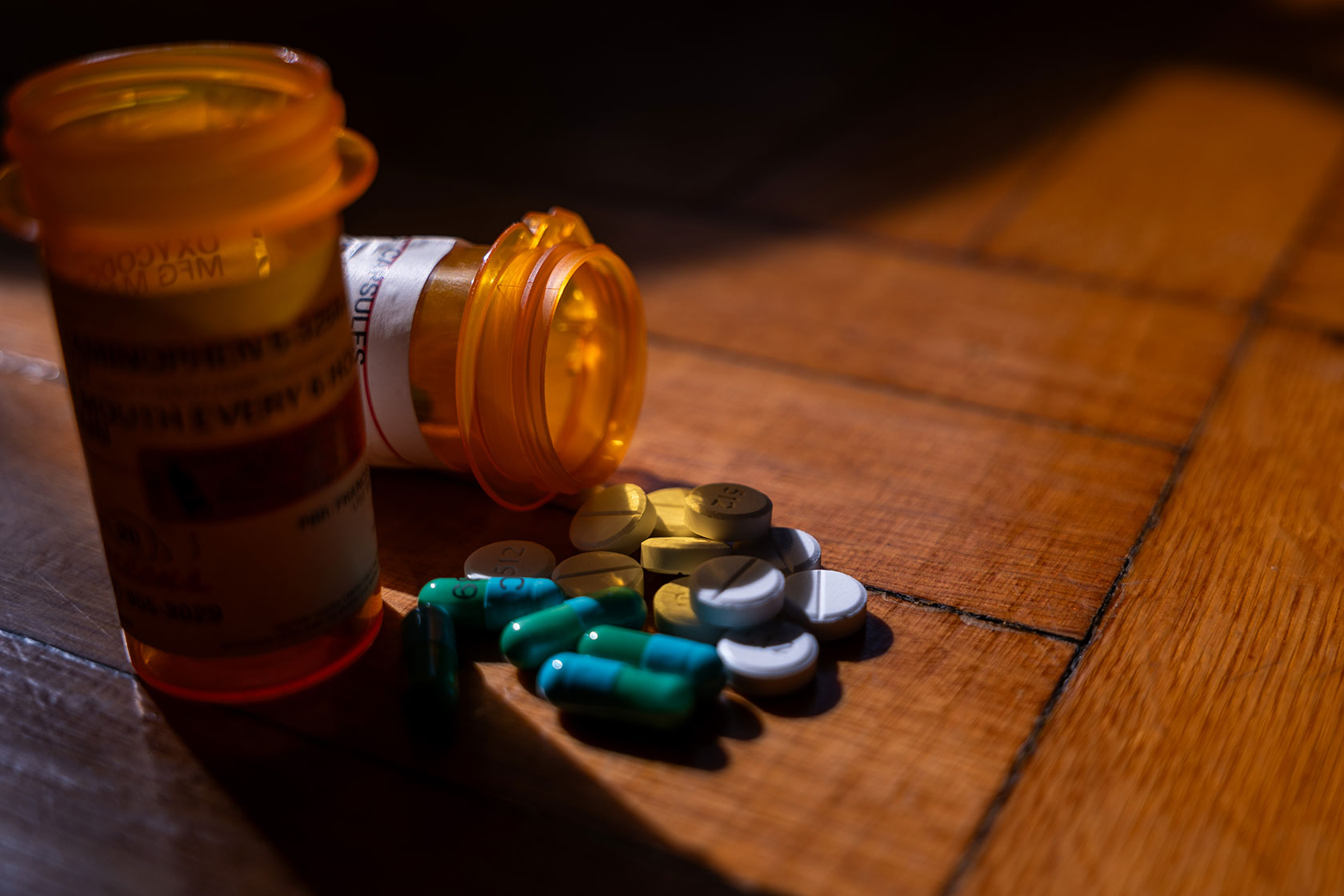 Pill bottles, and pills spilled, on a surface