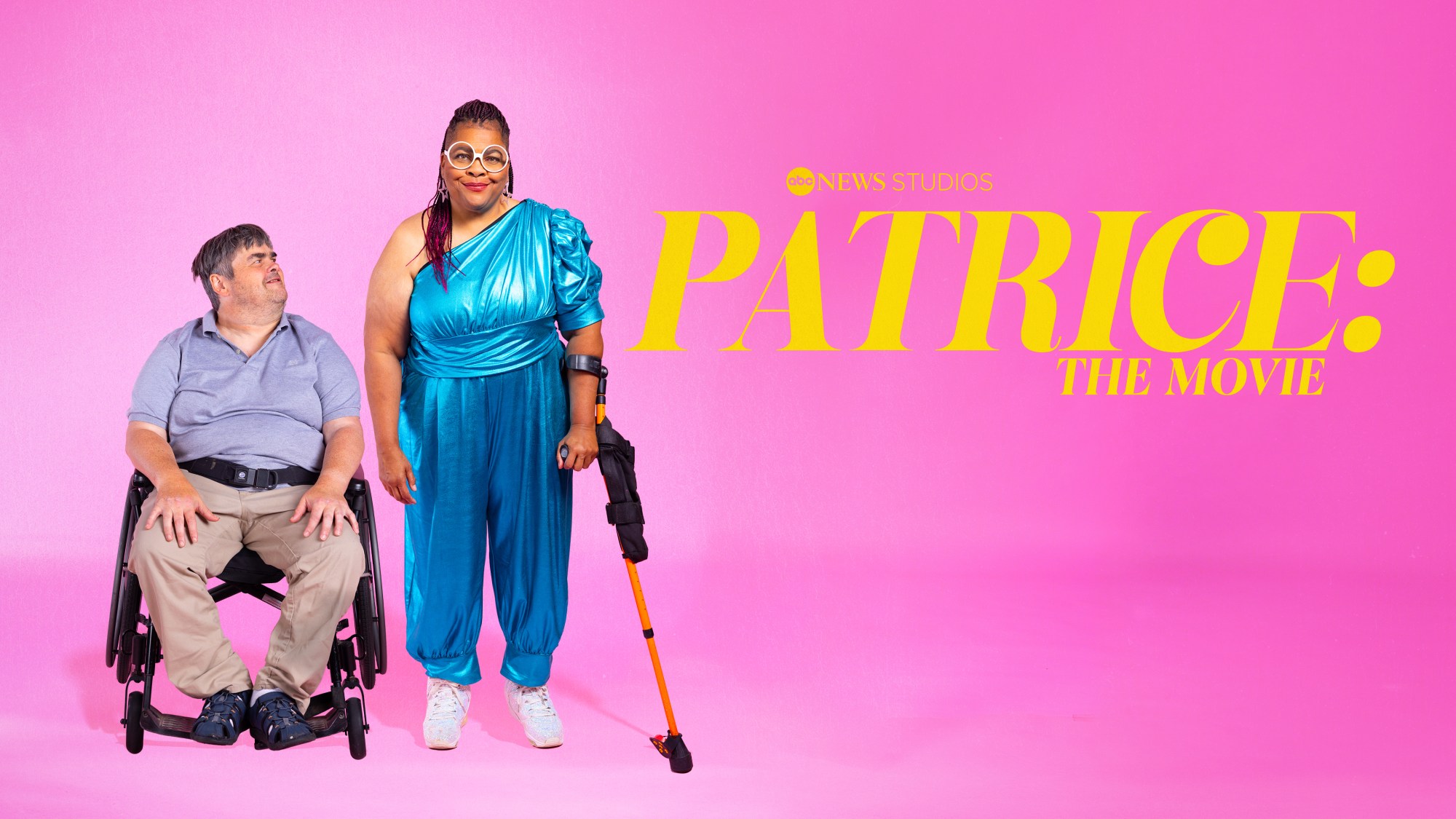 Film promotion for 'Patrice: The Movie,' Garry and Patrice are on a pink background. Garry is in a wheelchair looking up at Patrice. Partrice is wearing glasses and a walking aide smiling at the camera.