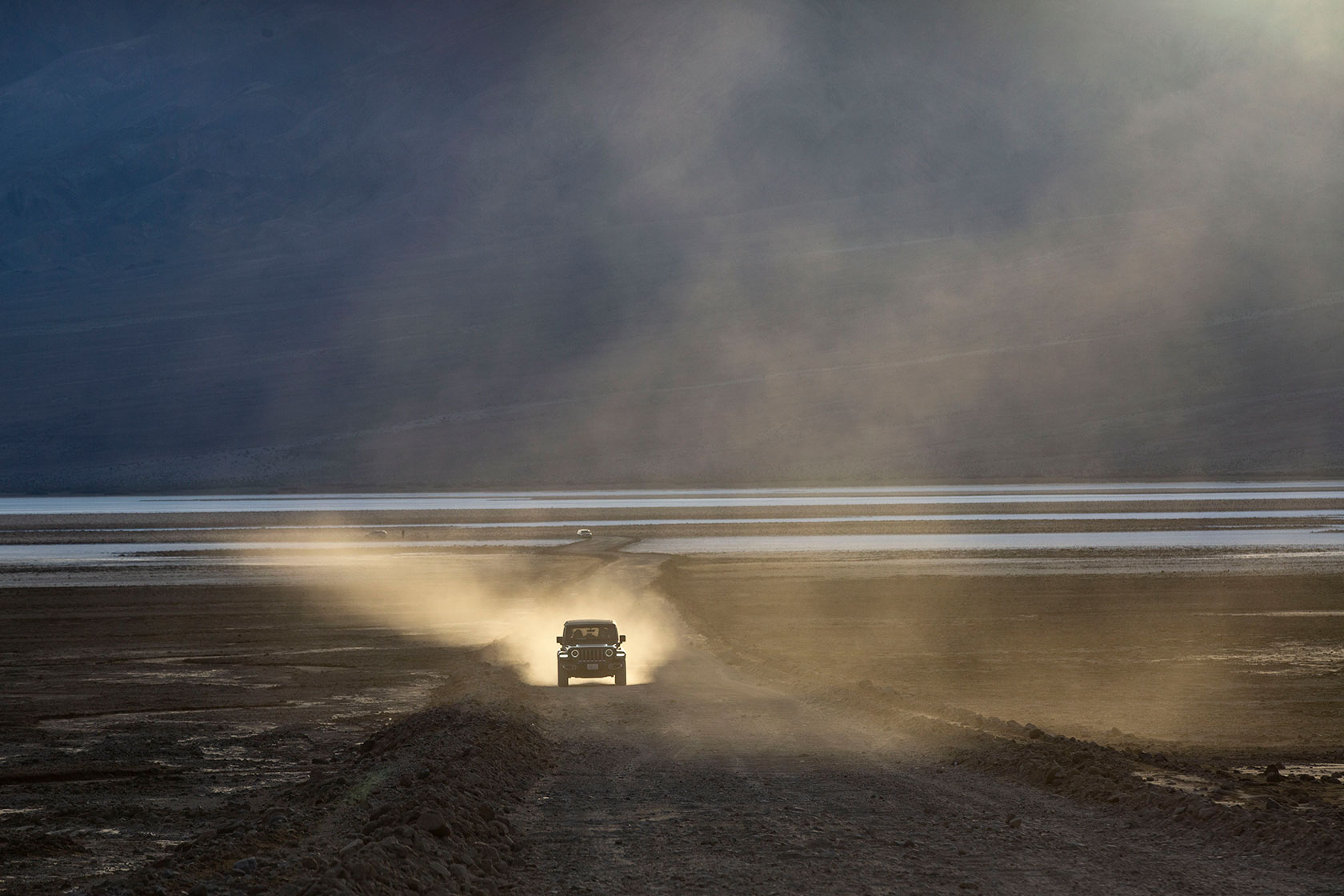 An SUV driving down a road, facing the camera