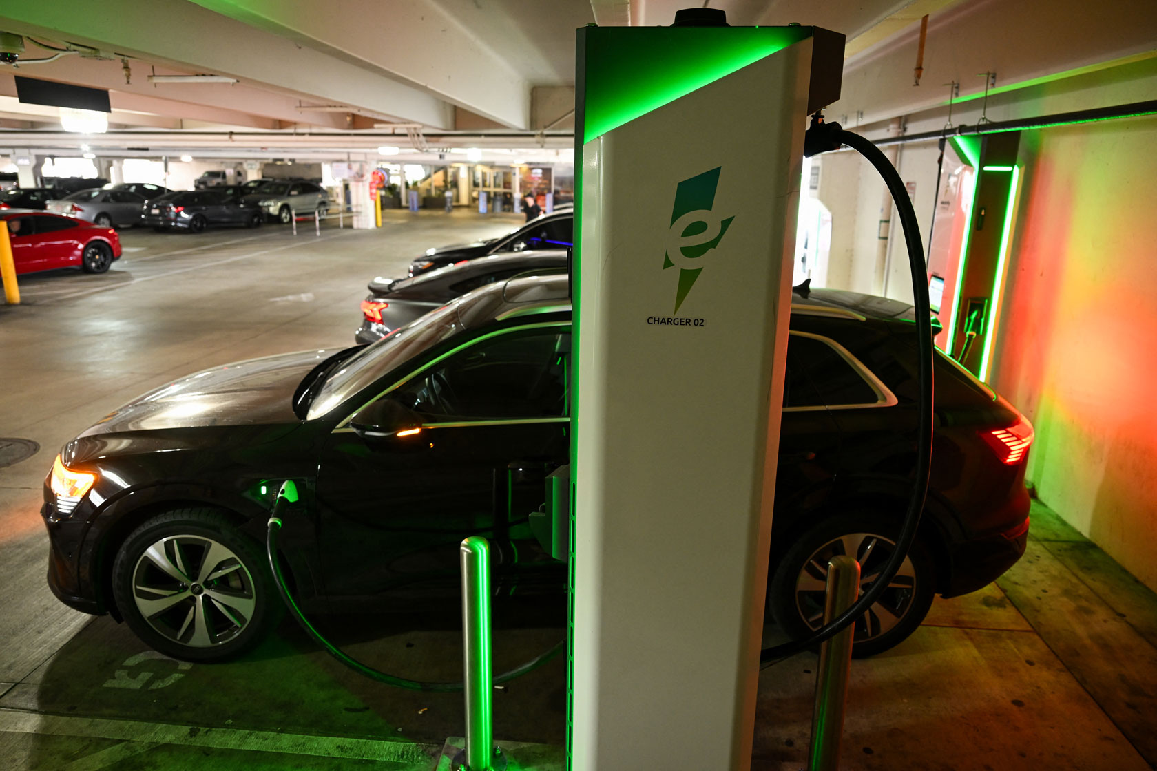 An electric car charges in a parking garage.