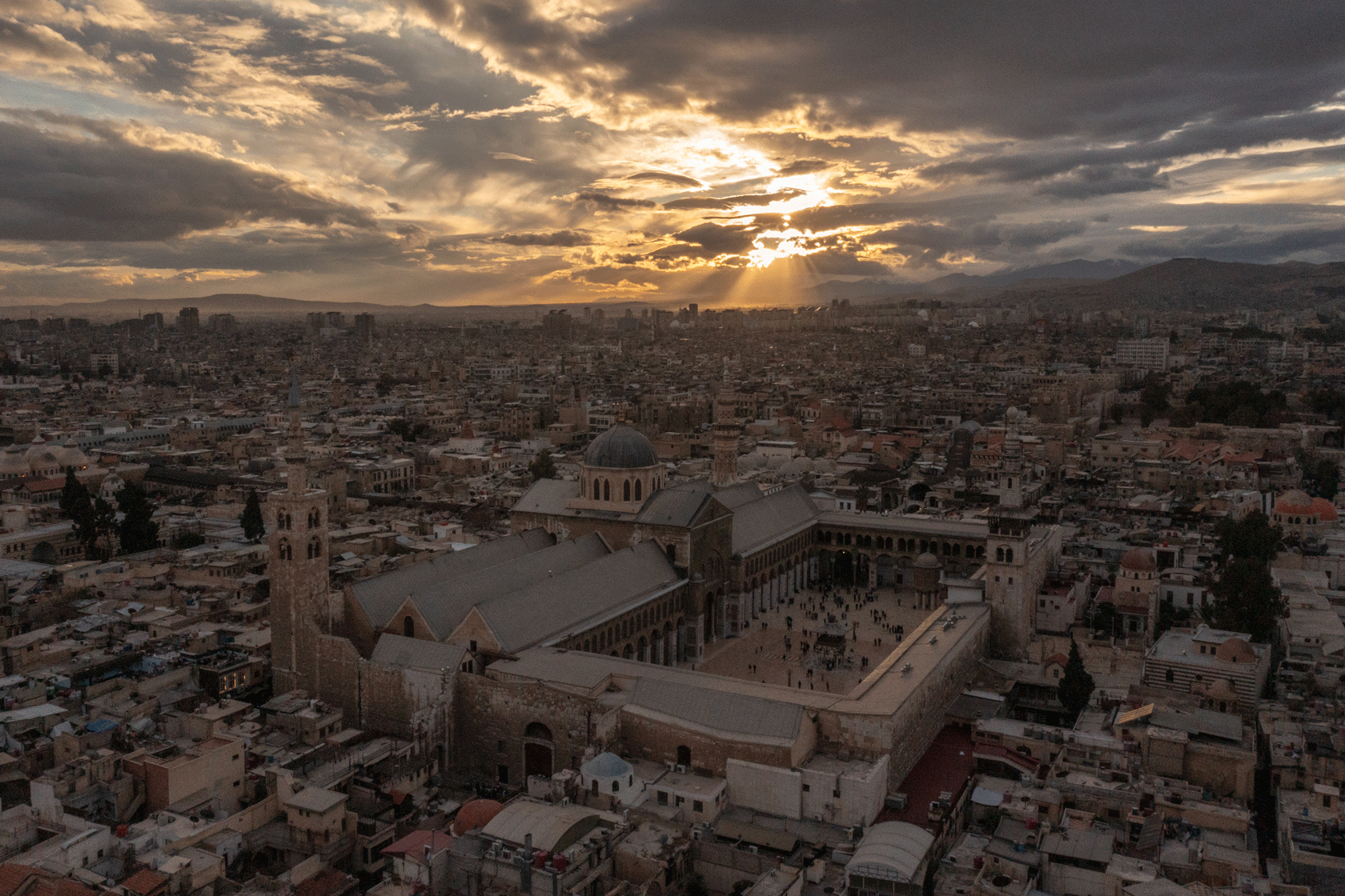 The sun is seen setting over the city of Damascus.