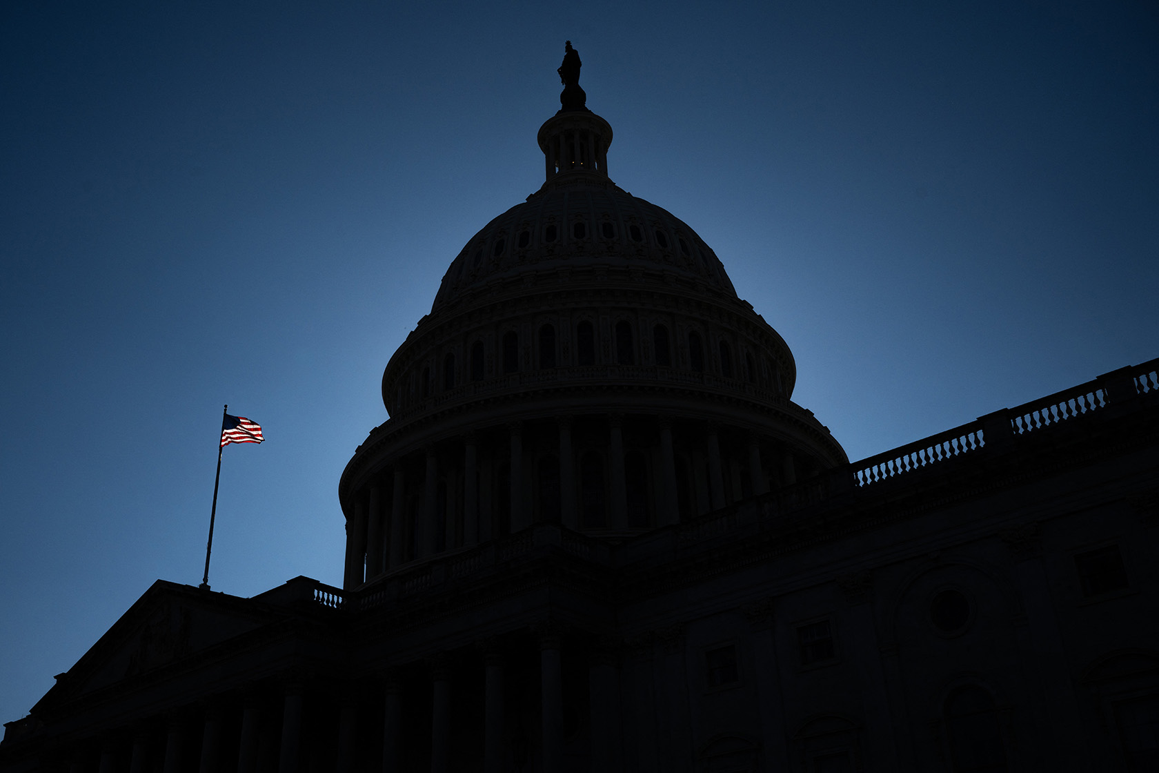 A U.S. flag flies near the dome of the U.S. Capitol.
