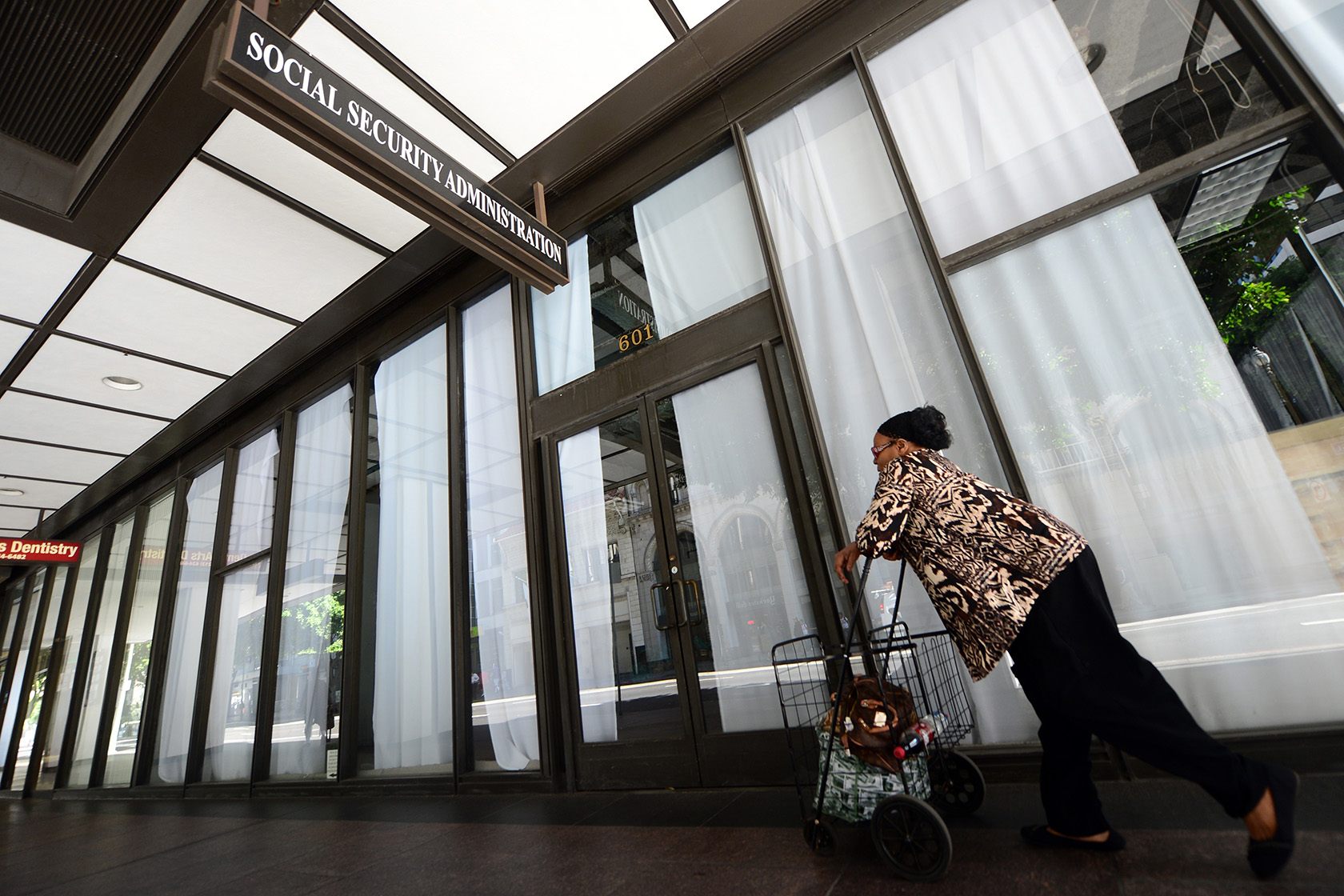 A woman walks past a Social Security Administration office in downtown Los Angeles.