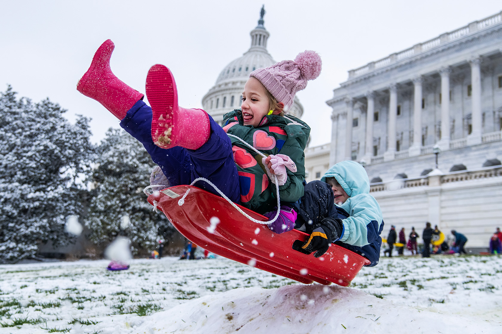 Children sled on the West Front of the U.S. Capitol.