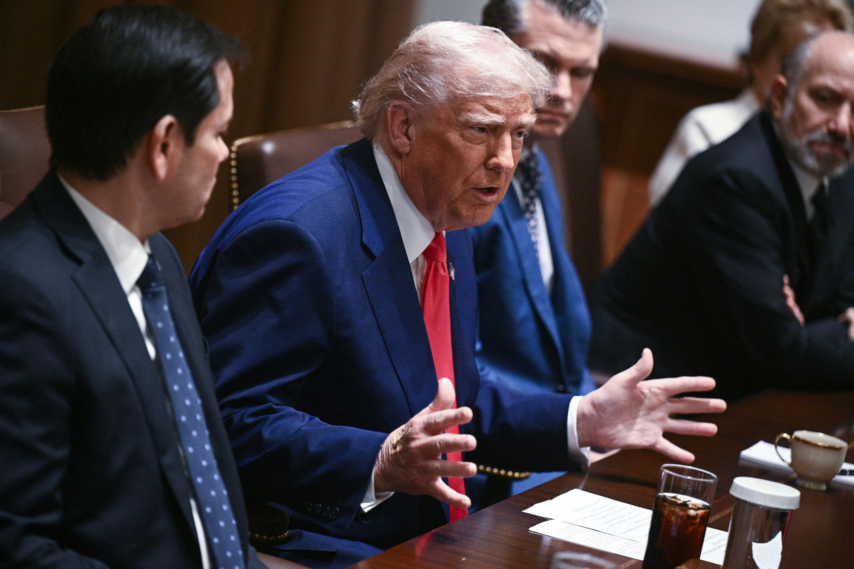 President Donald Trump is seen sitting at a table with members of his Cabinet.