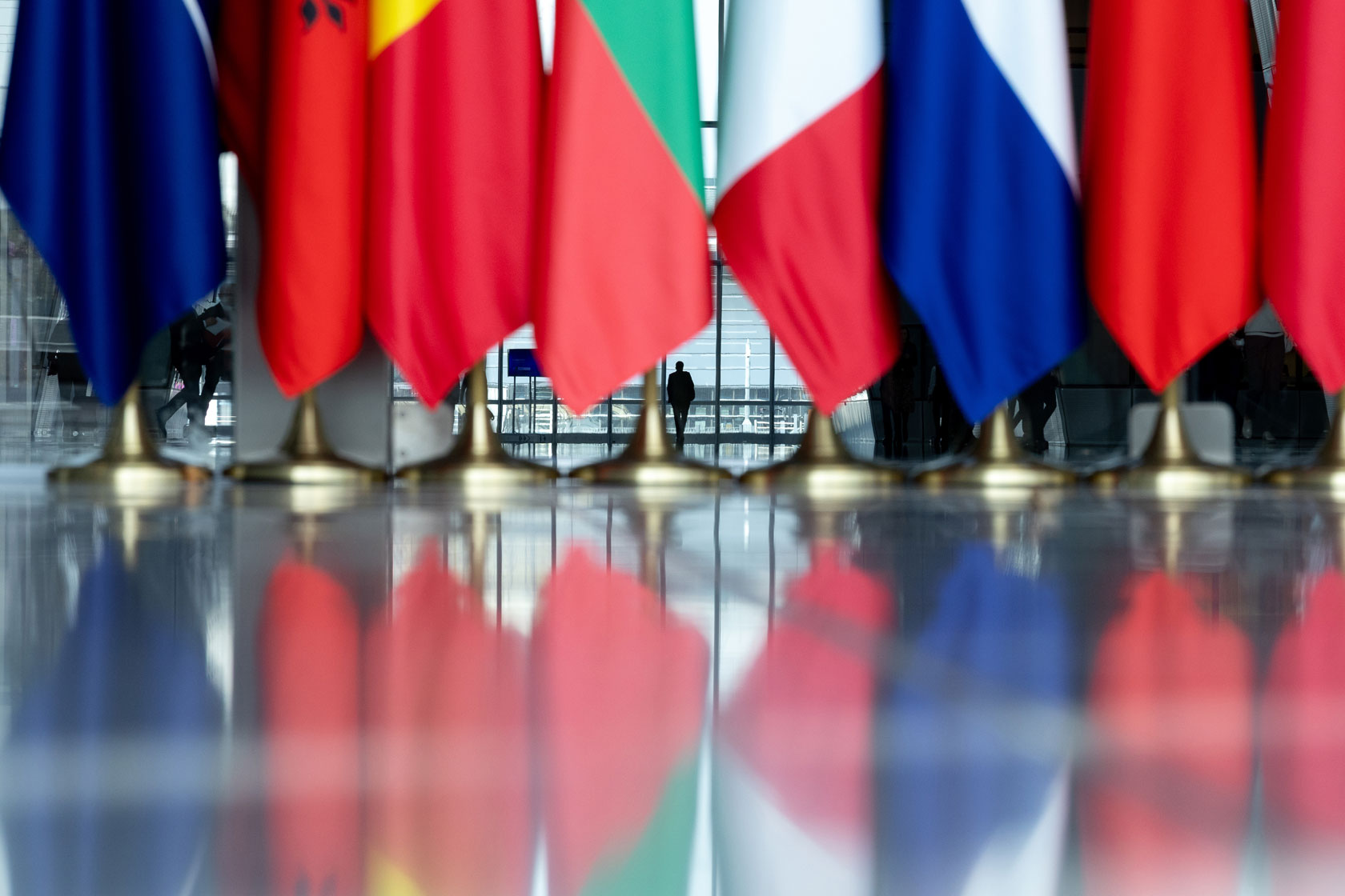 The bottom of flags are seen in an office building.