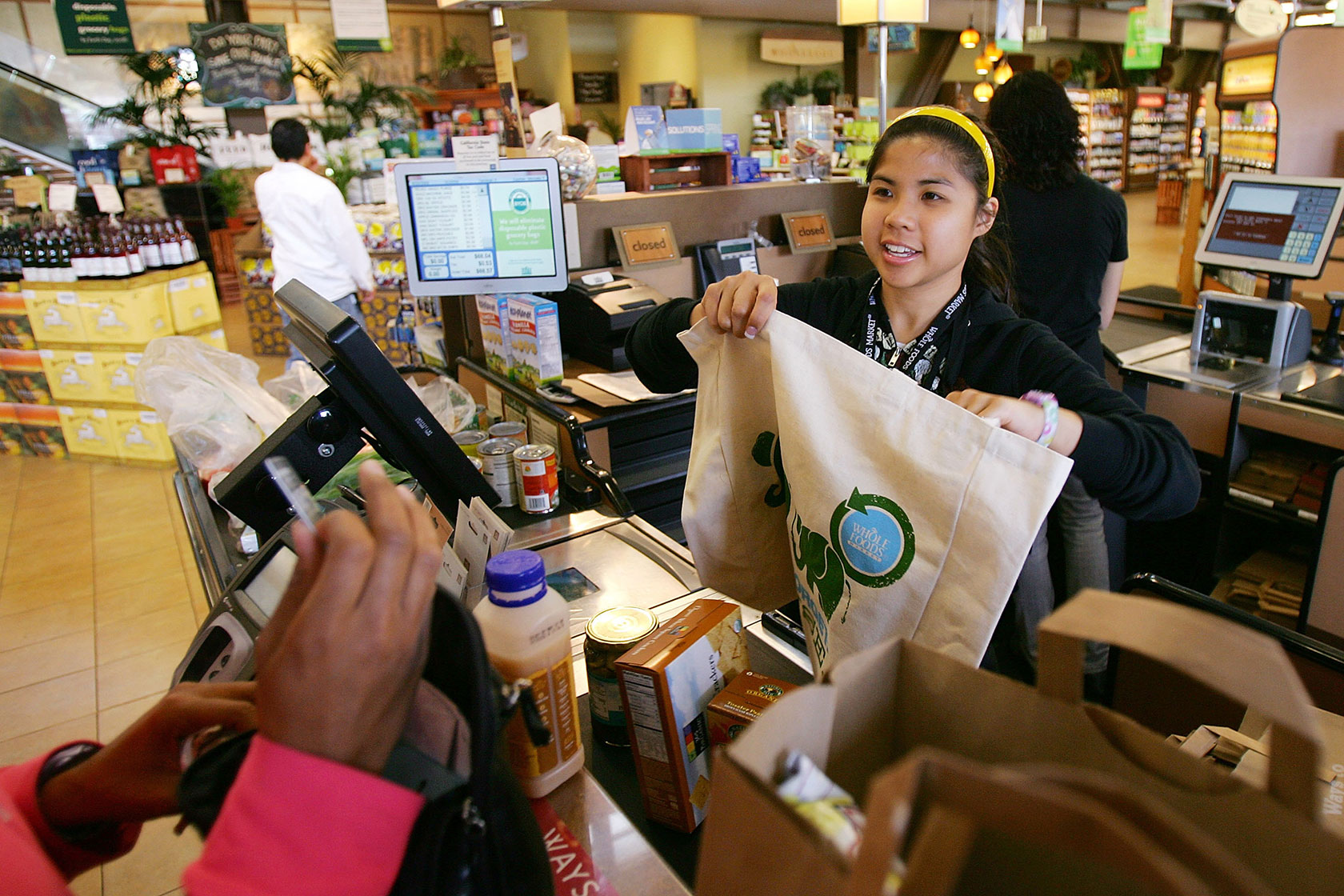 Cashier hands out grocery bags
