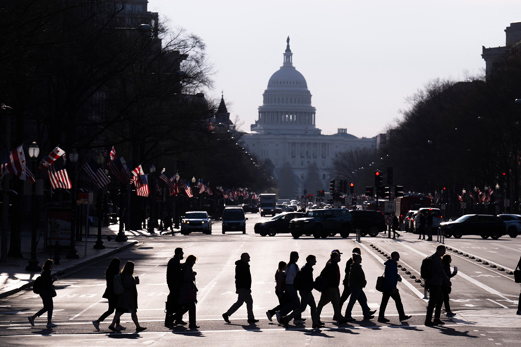 Commuters cross Pennsylvania Avenue in downtown Washington, D.C., as they head toward U.S. federal government office buildings.