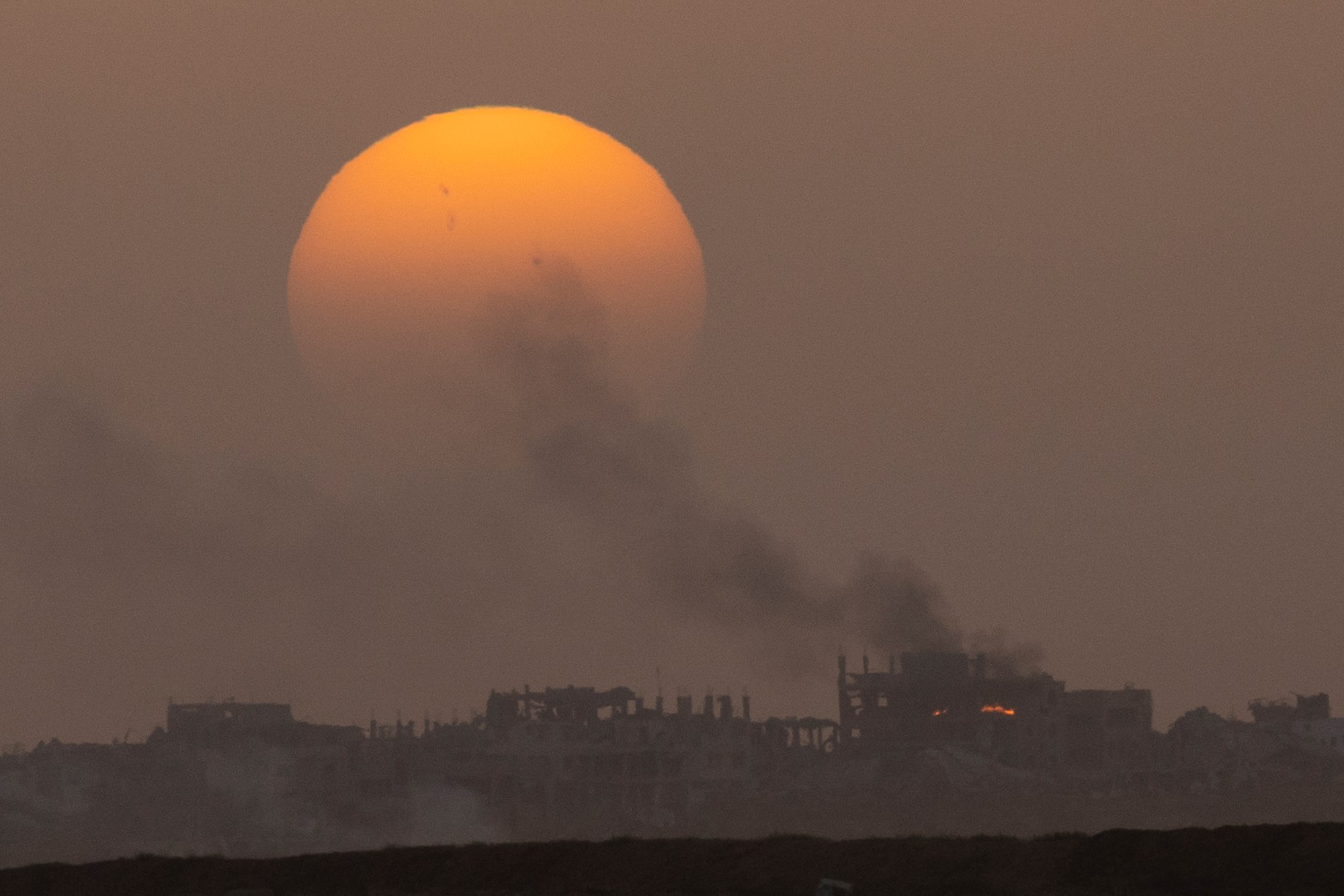 Smoke rises over a ruined building in Gaza.