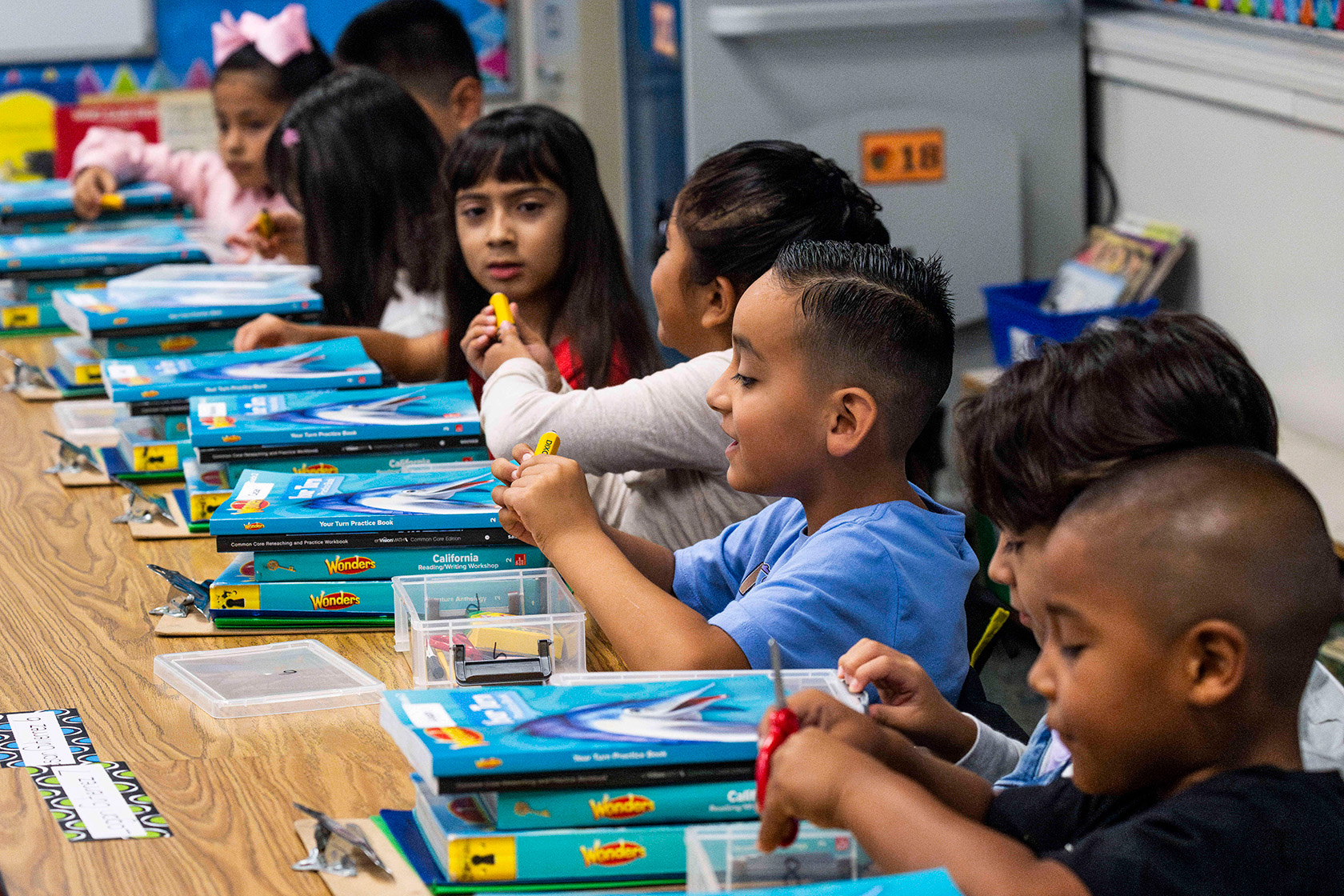 Second-grade students check out books and other items during the first day of class.