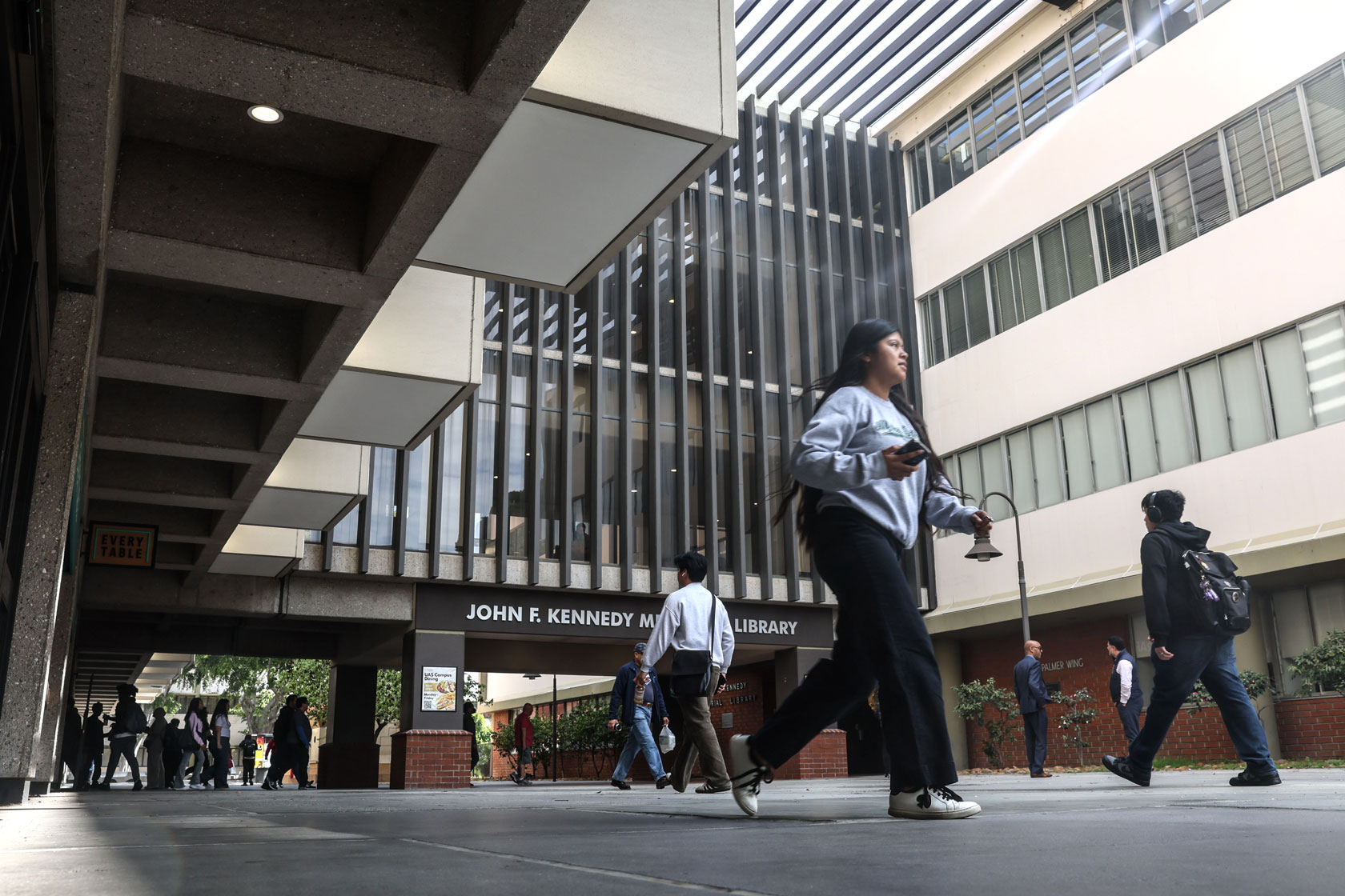 Students are seen walking across a college campus.