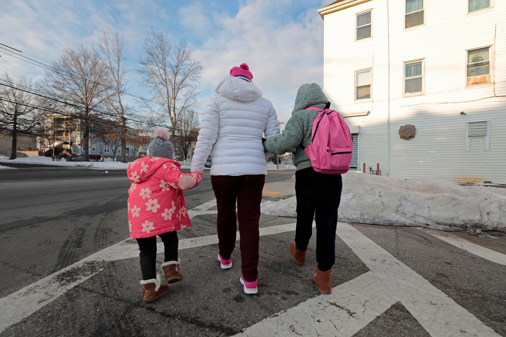 A woman walks with her children, February 24, 2025.
