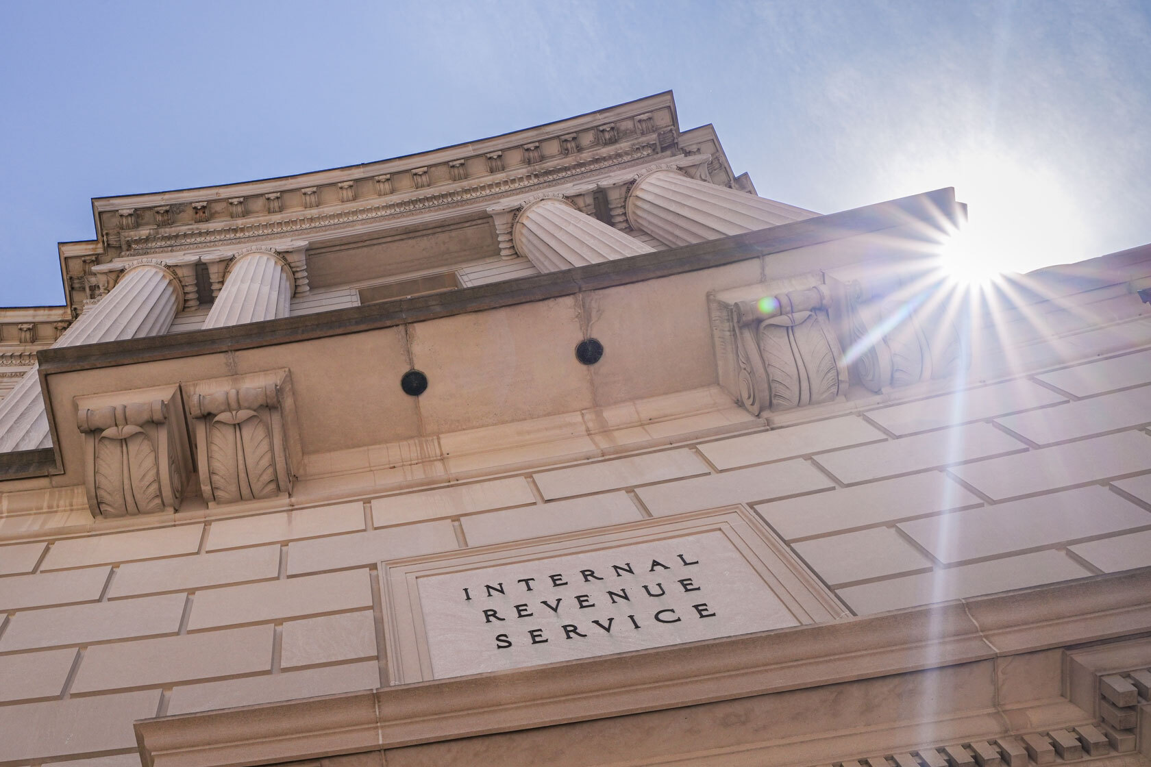 The sun flares over the top of the Internal Revenue Service.