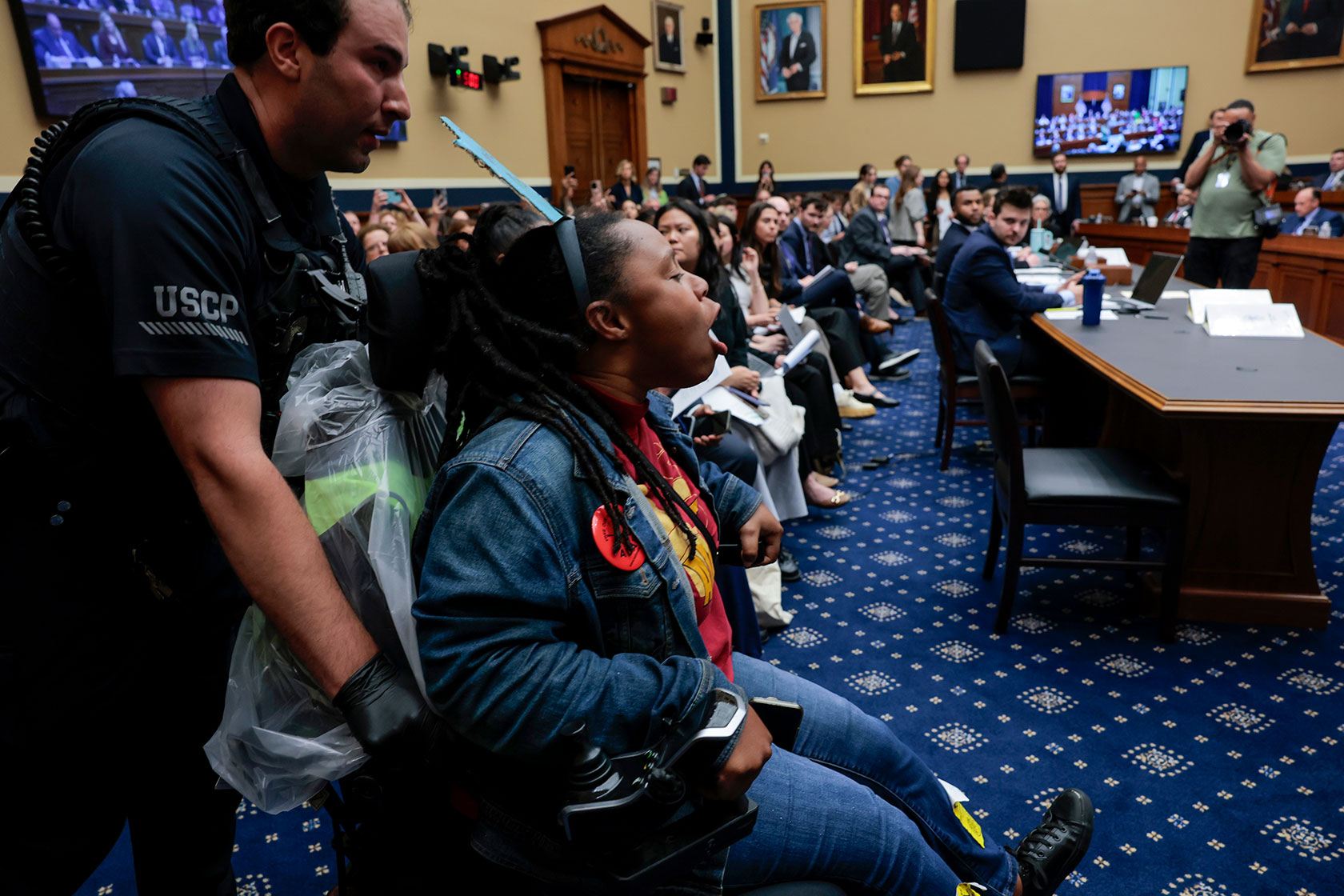 Capitol police removing protestor in wheelchair from House hearing