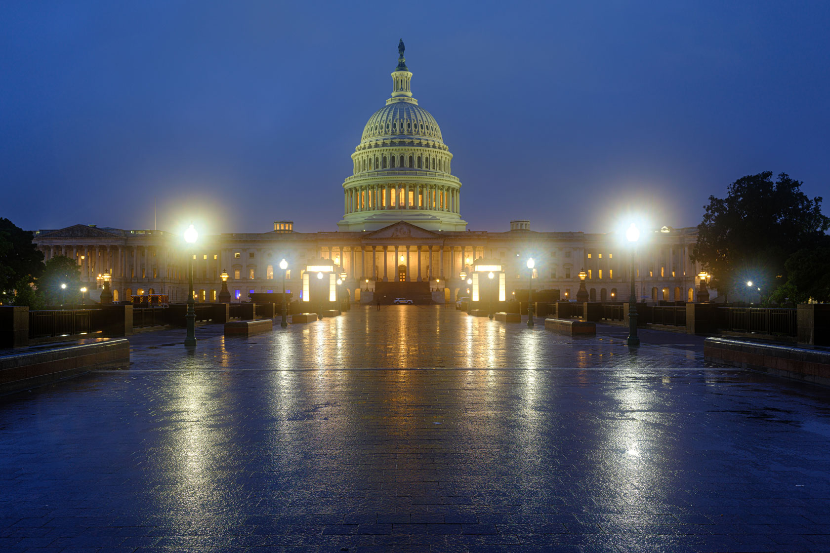 The dome and building of the U.S. Capitol are illuminated against the backdrop of a predawn sky.