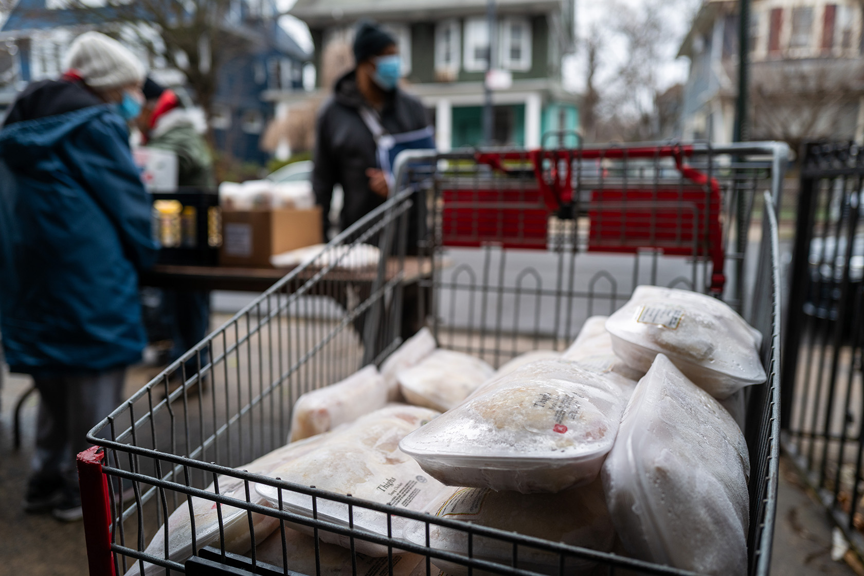 Frozen chickens sit in a shopping cart at a food bank.