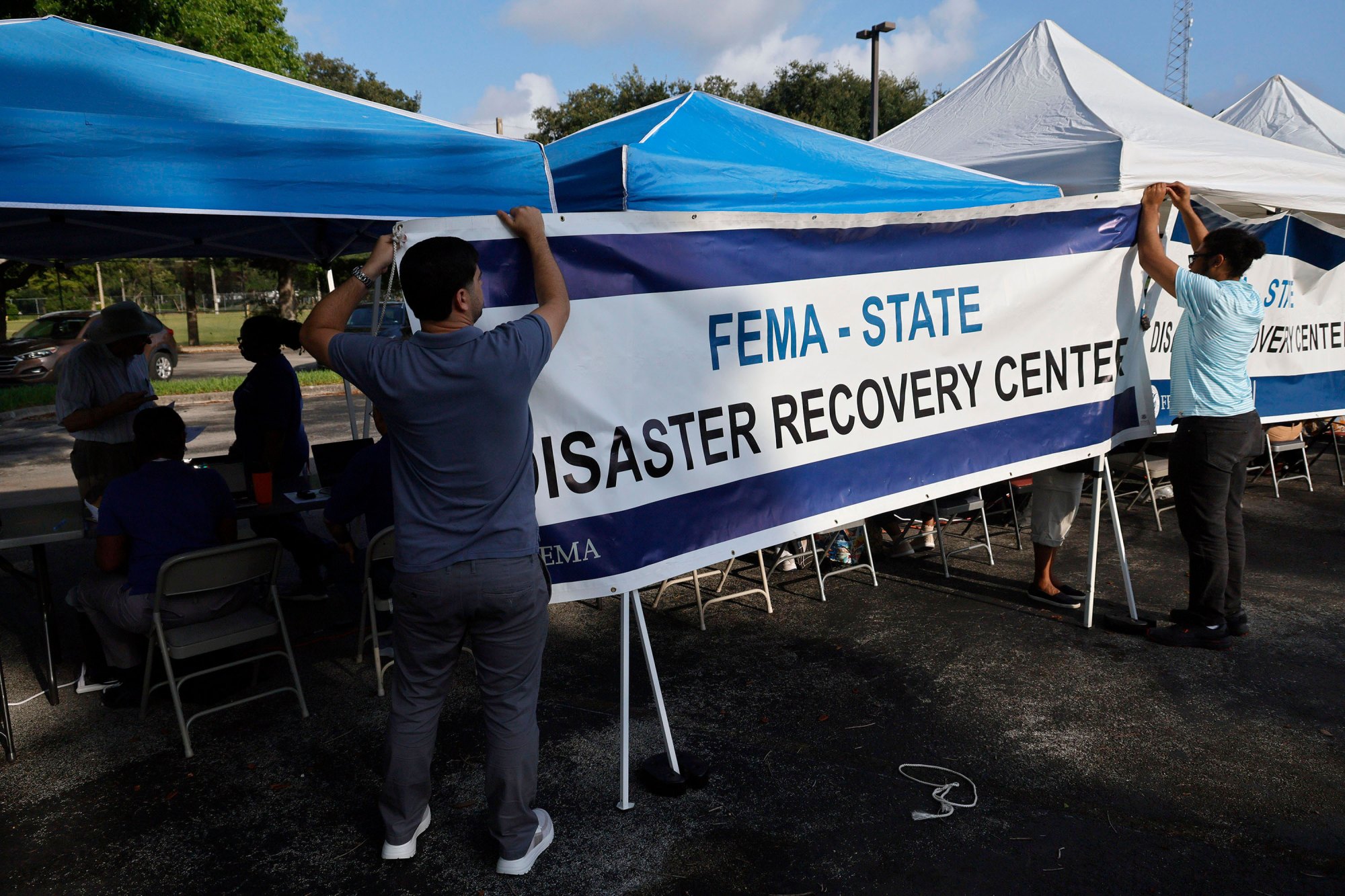 FEMA employees hang a banner at a disaster recovery center in Hollywood, Florida.