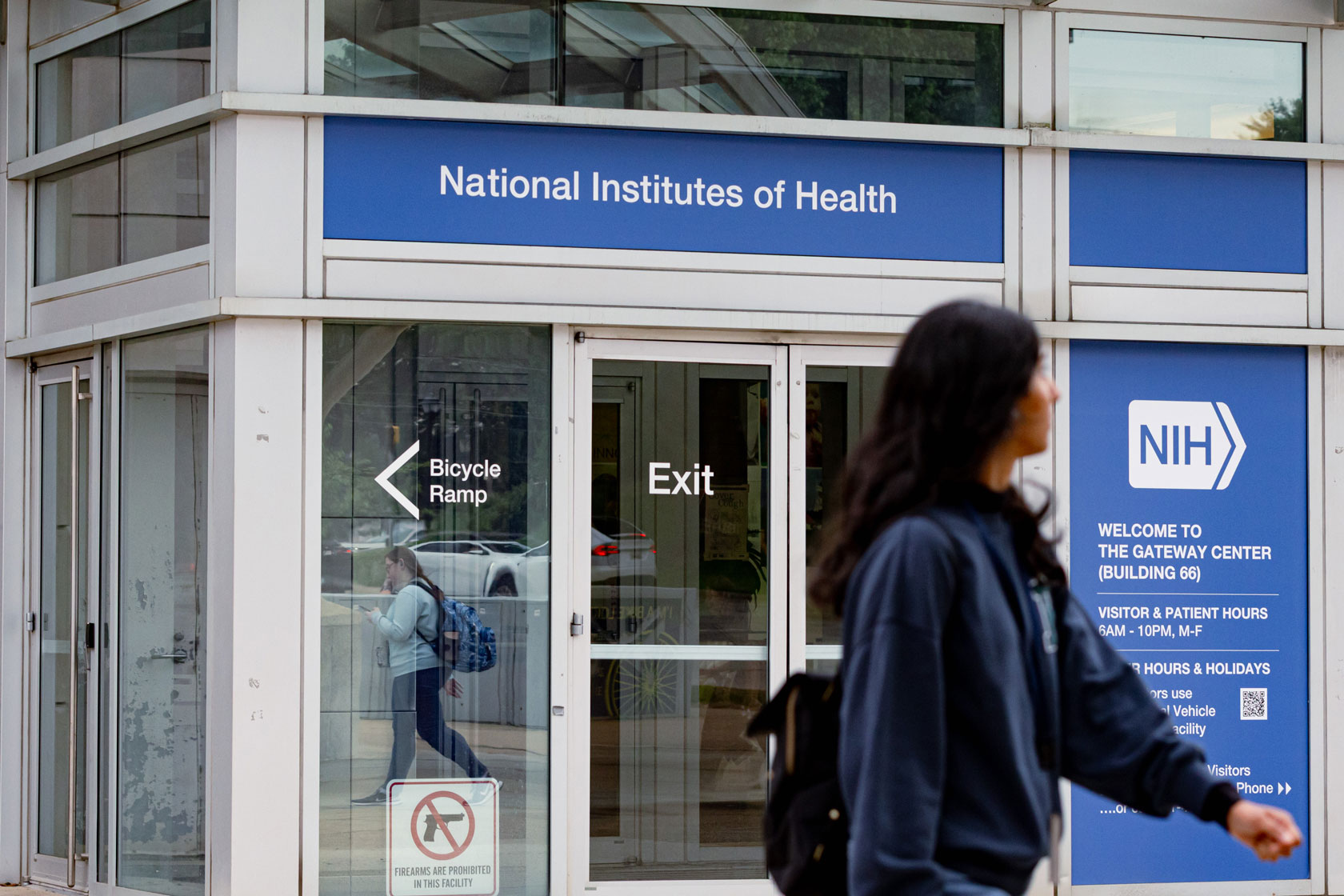 People walk near the metro station in front of the National Institutes of Health headquarters on May 20, 2025, Bethesda, Maryland.