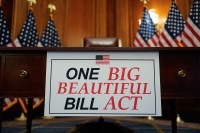 A sign that reads “One Big Beautiful Bill Act” is seen by a desk.