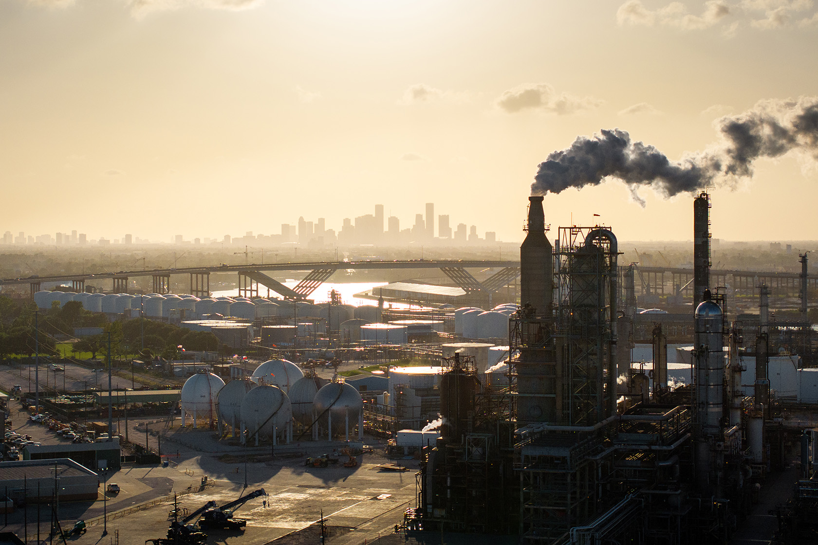 The sun sets behind a refinery in Houston.