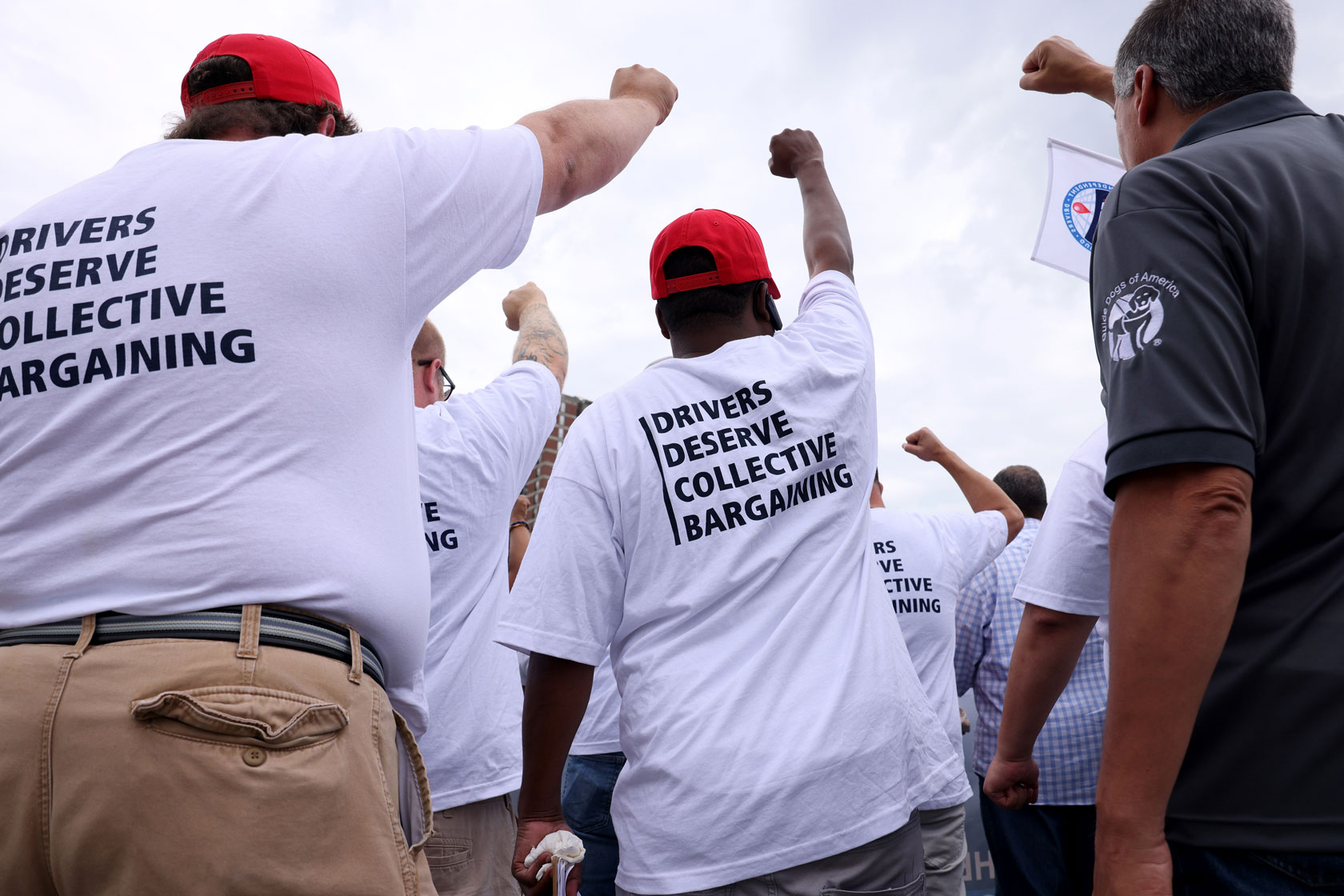 Uber and Lyft drivers raised their fists, demanding legislative action to improve their jobs in Allston, Massachusetts.
