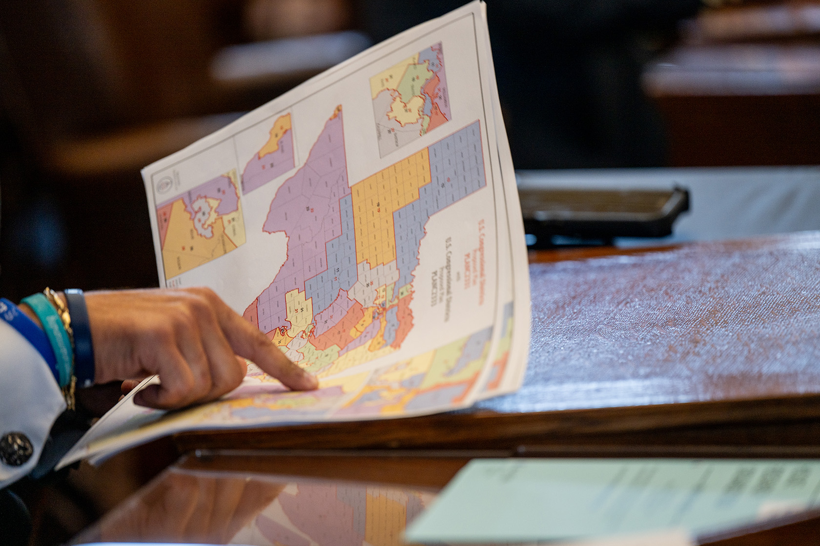 A Texas lawmaker views a congressional district map during a House meeting.
