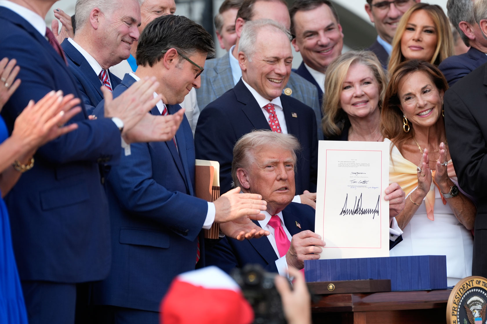 President Donald Trump holds up the One Big Beautiful Bill Act after signing it into law on July 4, 2025, Washington, D.C.