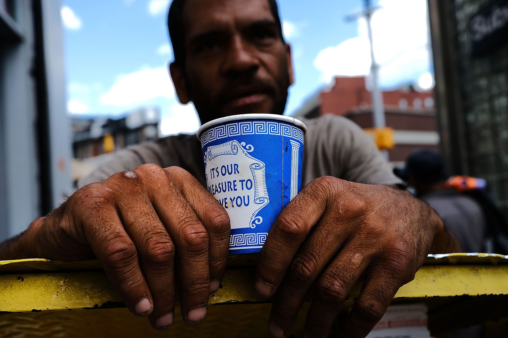 A man panhandles in New York City.
