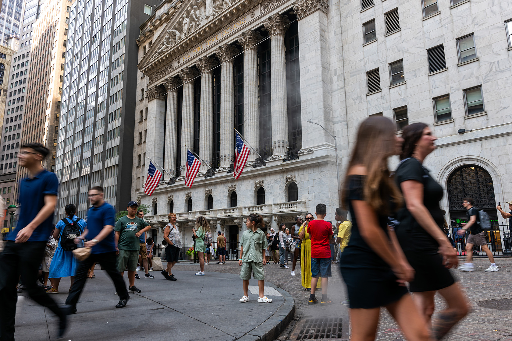 People walk through the financial district by the New York Stock Exchange.