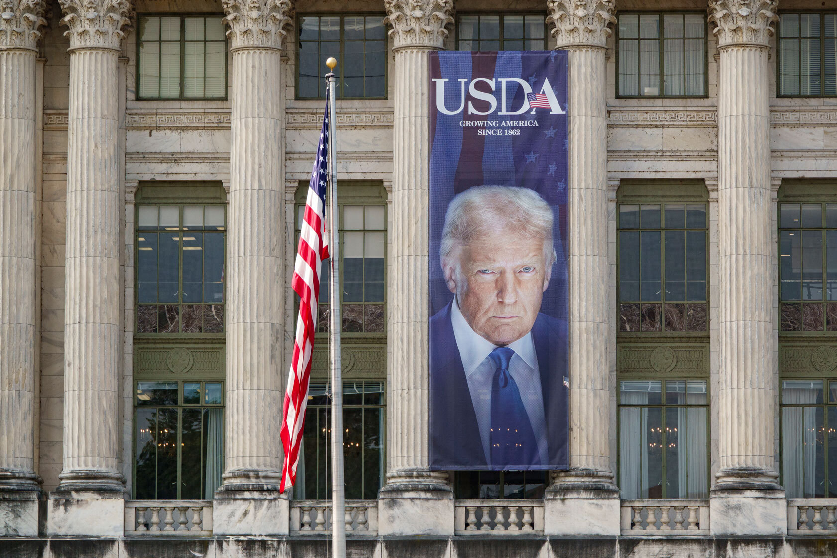 A banner showing a picture of U.S. President Donald Trump is displayed outside of the U.S. Department of Agriculture.