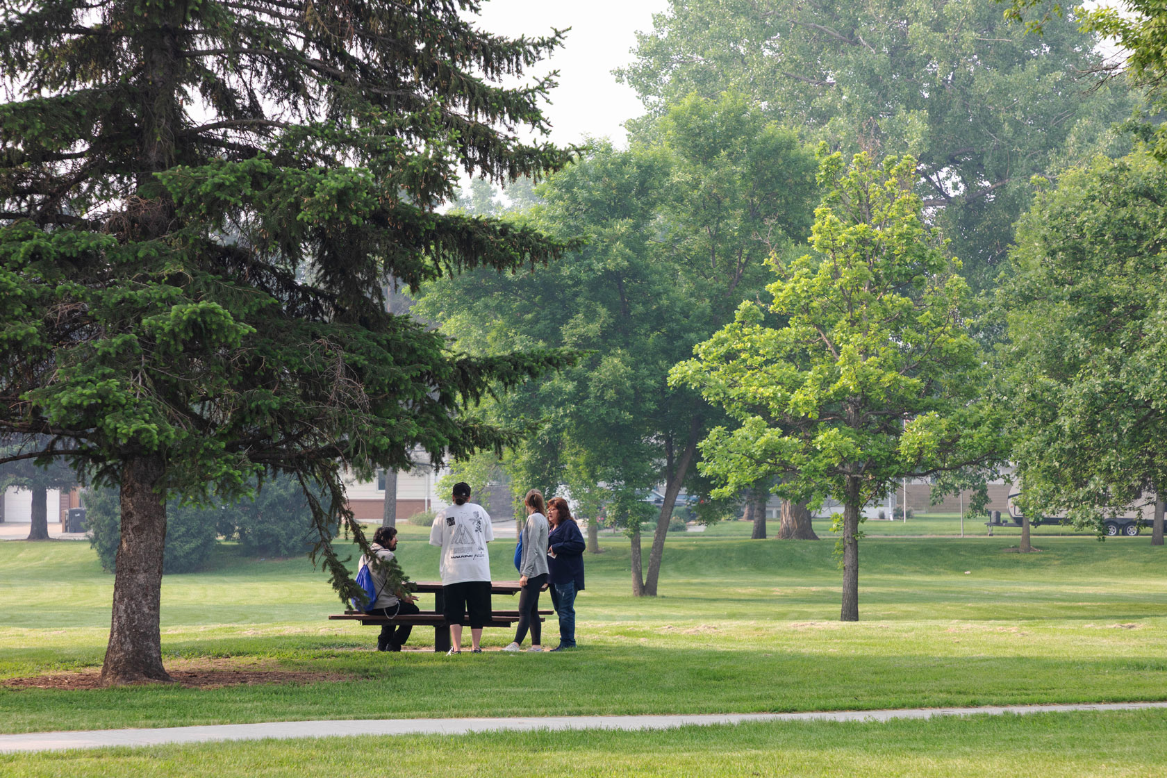 Social workers provide a man experiencing homelessness with resources in a local park in Bismarck, North Dakota.