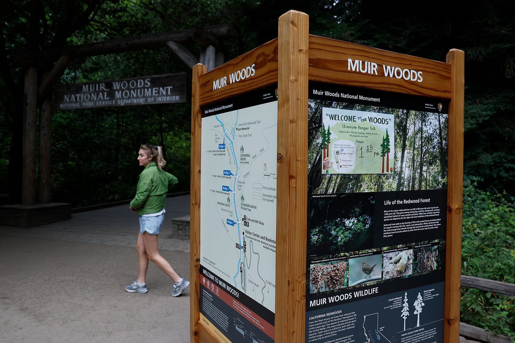 Person entering national monument past large welcome map
