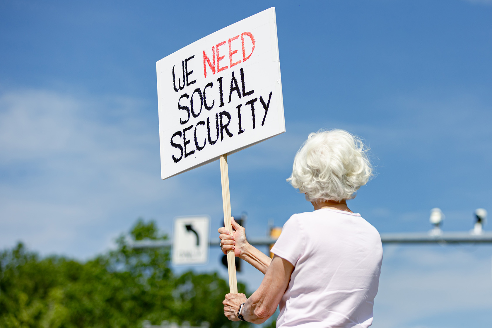 A woman holds a sign in support of Social Security.