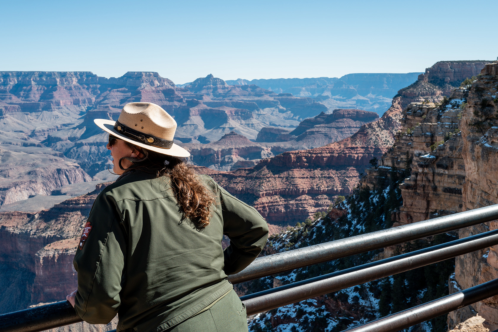 A Grand Canyon National Park ranger looks out from the South Rim while giving a tour to visitors.