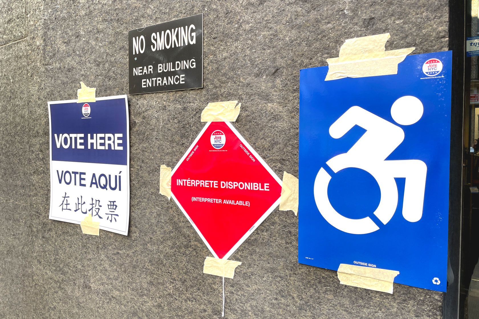 Signs in English, Spanish, and Chinese and indicating accessibility inform registered voters of where to cast their ballots in New York.