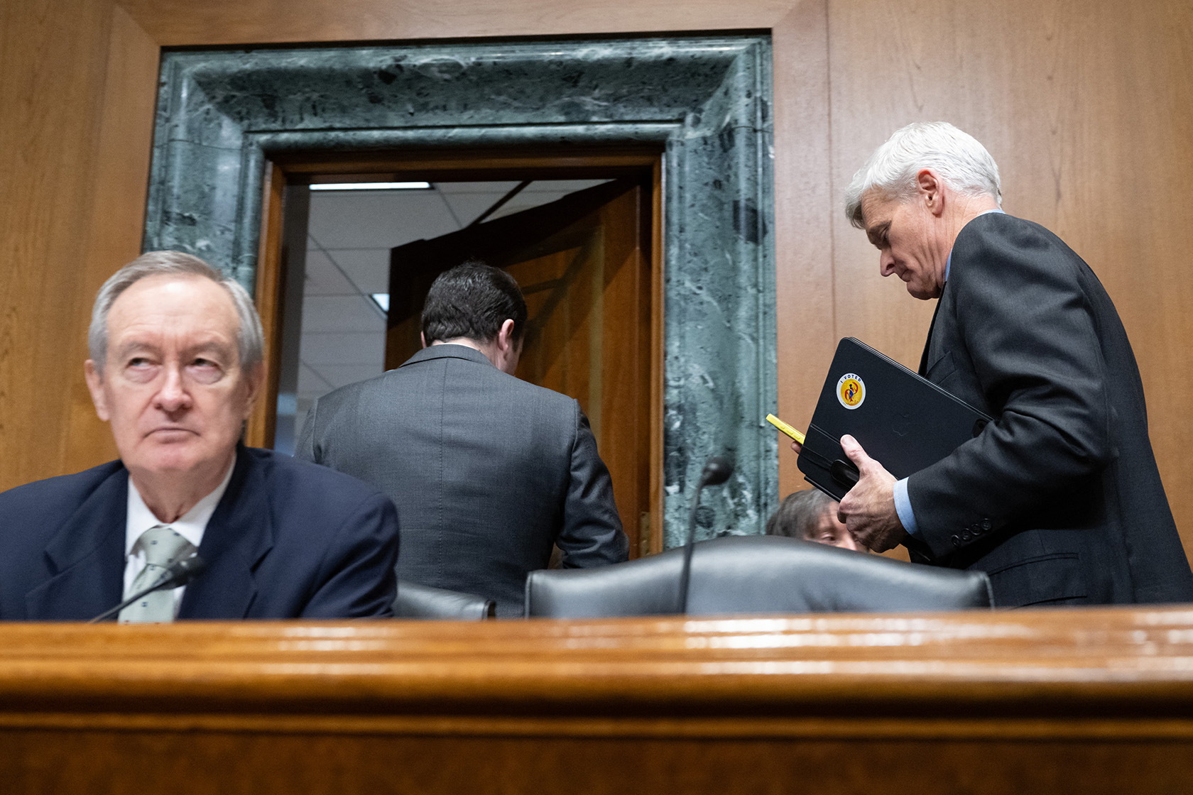 Sen. Bill Cassidy leaves a U.S. Senate Finance Committee meeting past Committee Chairman Sen. Mike Crapo.
