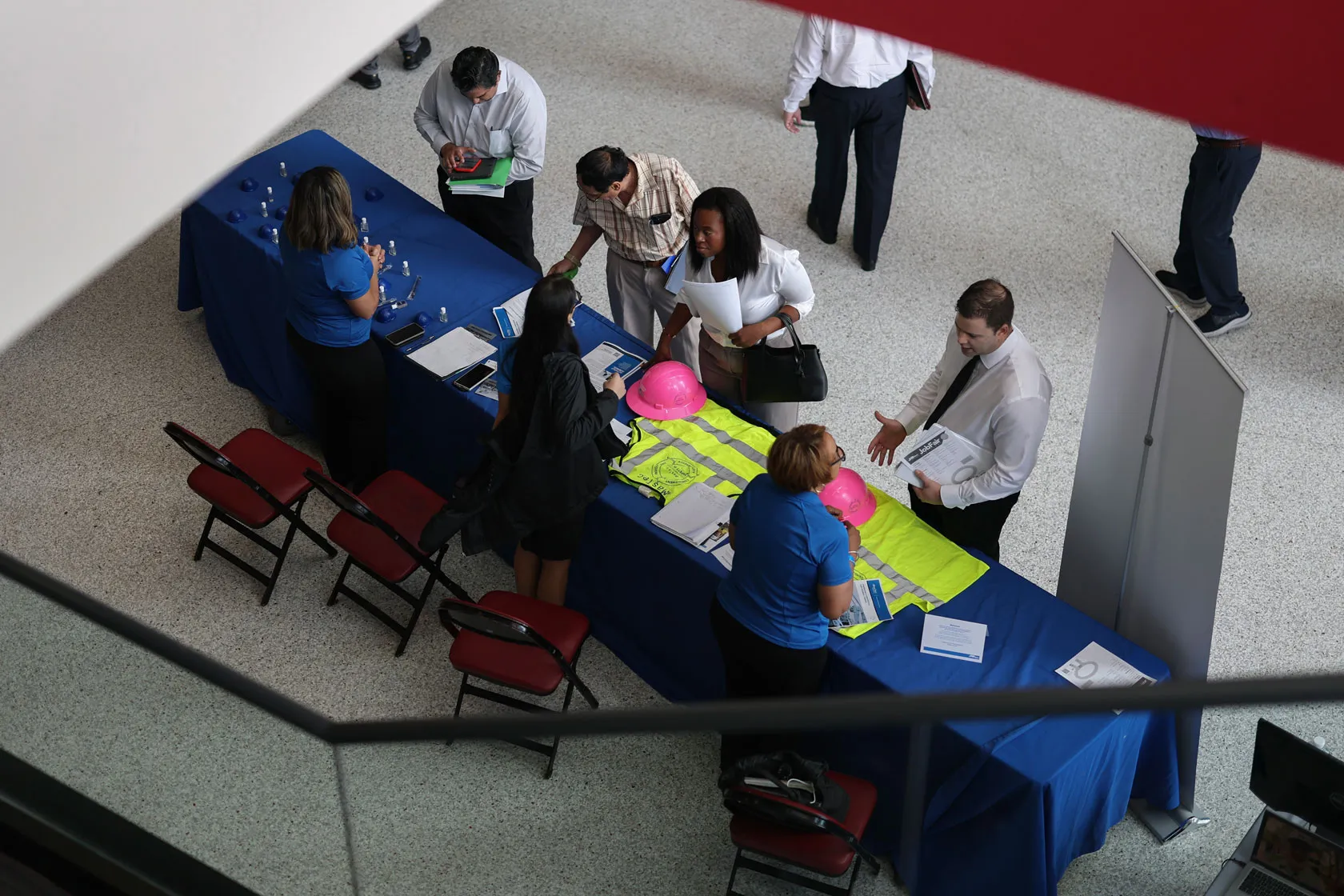 Job seekers stand around a table at at a job fair.