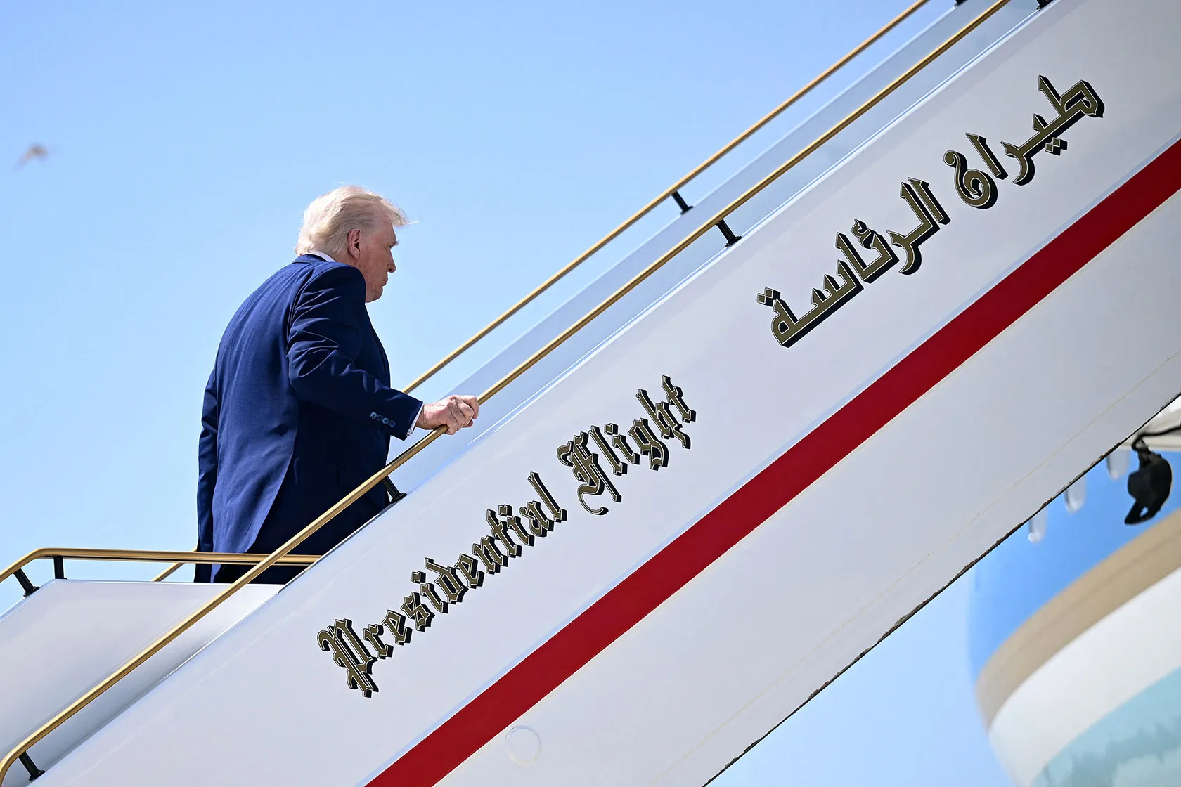 Trump walking up stairs to plane