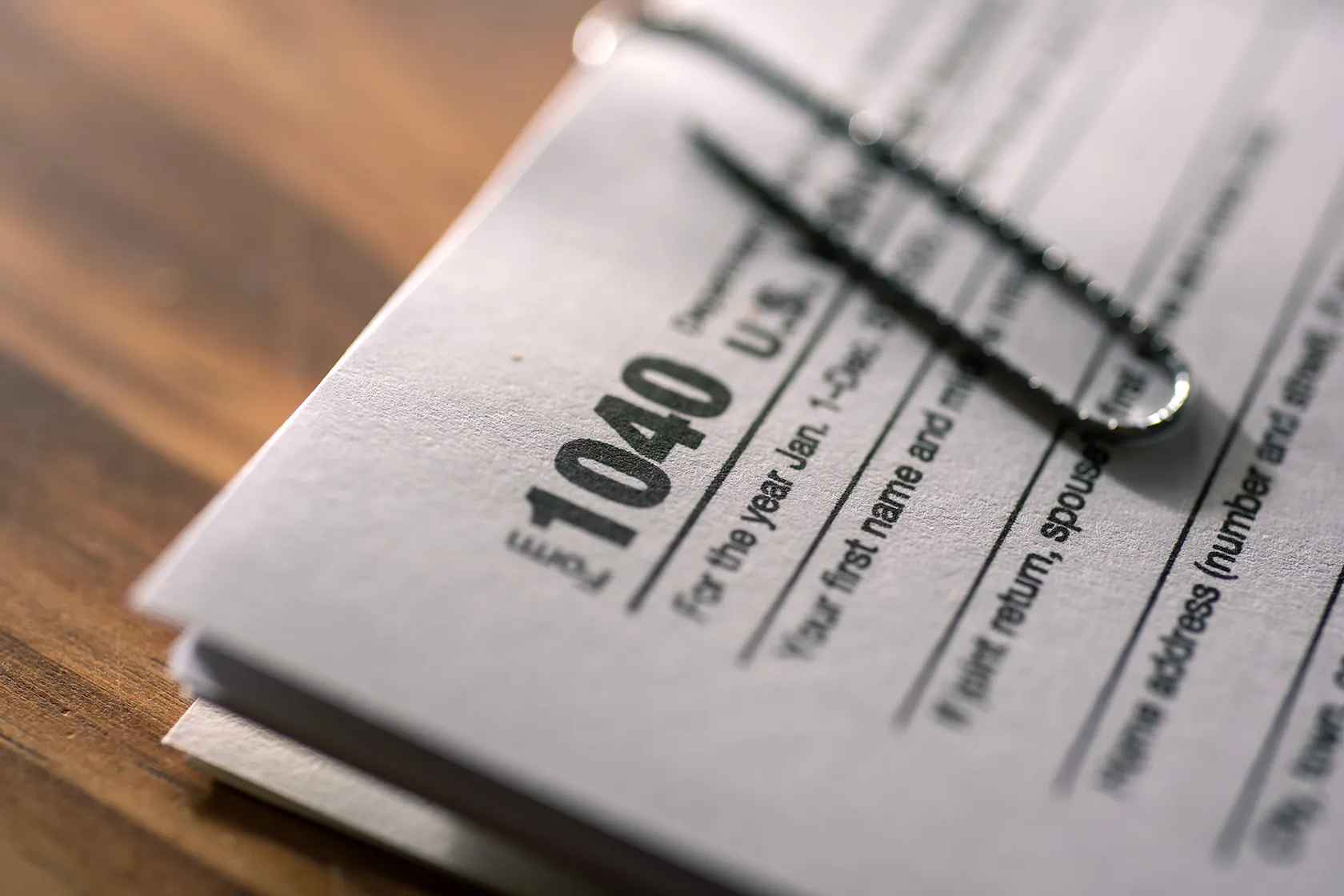 A 1040 U.S. individual income tax return document is seen on a desk.