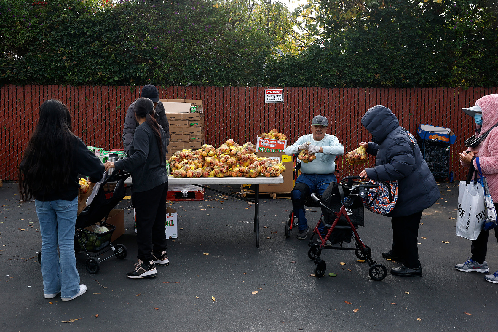 People in need receive groceries during a free food giveaway.